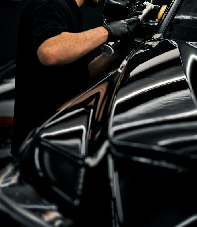 a man waxing a car in a garage
